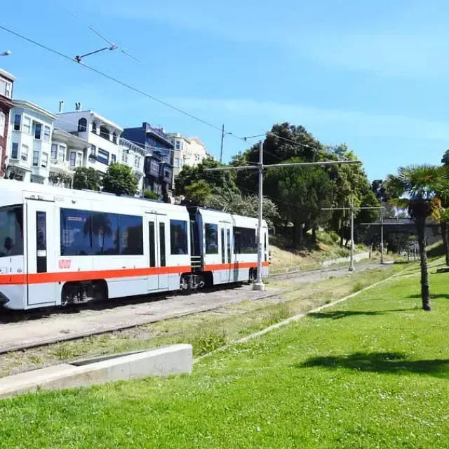 A MUNI passenger train runs along a track in San Francisco.